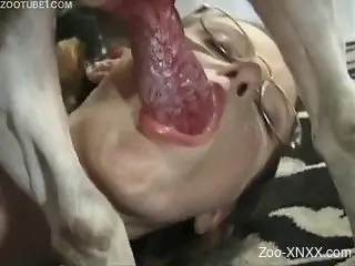 Blonde gets on all fours to suck this dog's meaty cock